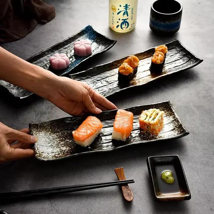 Assiette en céramique noire à rayures pour sushi