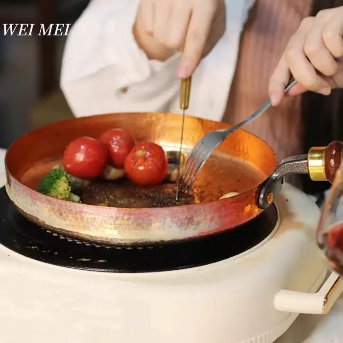 Poêle plate en cuivre artisanale rétro pour dîners de style occidental et pique-niques au feu de camp, avec manche en bois pour une prise en main confortable et une utilisation pratique à la maison ou en extérieur